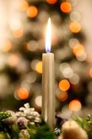 una vela de adviento con árbol de navidad en el fondo foto