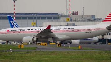 dusseldorf, alemania 23 de julio de 2017 - airbus a330 203, tc jnc de turkish airlines paseos en librea retro en la calle de rodaje en el aeropuerto de dusseldorf. dreamliner all nippon airways en la terminal video