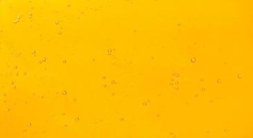 Golden liquid with bubbles full screen abstract wallpaper background. photo