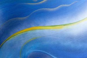 Abstract plaster wall background painted in blue and decorated with golden yellow curves. photo