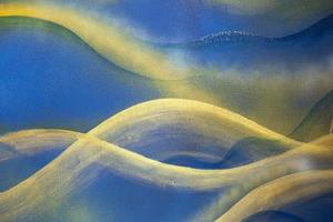 Blue abstraction and golden curves on plaster wall background. photo