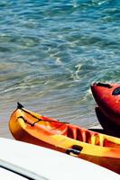 Active rest, sport, kayak. Boat for rafting on water. A few kayaks stand on a sandy beach. photo