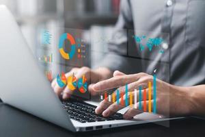 Businessman analyzing company's financial balance sheet working with digital augmented reality graphics. Businessman calculates financial data for long-term investment. photo