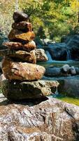 pirámide de piedras en las montañas. meditación y yoga bajo el sonido del agua video