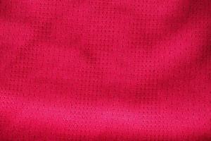 Red fabric sport clothing football jersey with air mesh texture background photo