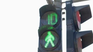 runda neon grön fotgängare trafik regulator med nedräkning tal. lysande ikon av en person på en fotgängare trafik ljus, funktionsduglig trafik ljus närbild. regler av de väg, trafik kontrollera. video