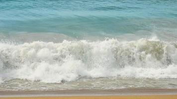 vågor rullad på de sand av mai khao strand, phuket, thailand. långsam rörelse video