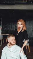 A young woman and her boyfriend are posing for the camera indoors. photo