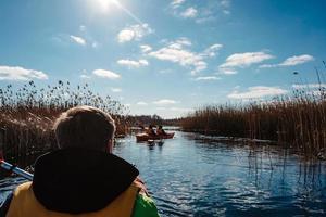 Group of people in kayaks among reeds on the autumn river. photo