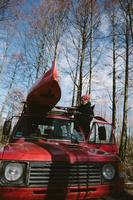 Man tying kayak on car roof in the forest photo