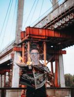 Guy reads a burning newspaper, in the background a bridge photo