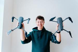 chico sostiene dos quadrocopters contra una pared foto