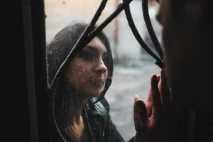 European young couple looking at each other through the window photo