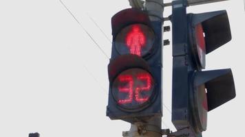 Round neon red pedestrian traffic regulator with countdown numbers. Glowing icon of a person at a pedestrian traffic light, serviceable traffic light close-up. Rules of the road, traffic control. video