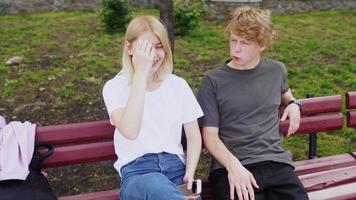 Girl relaxing with her boyfriend seated on a bench photo