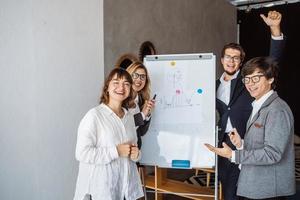 empresarios con pizarra discutiendo estrategia en una reunión foto