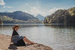 la chica del vestido y el sombrero del lago en las montañas foto