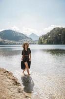 The girl in the dress and hat of the lake in the mountains photo