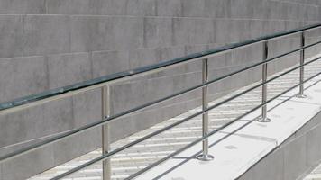 A ramp with stainless steel handrails for wheelchairs, bicycles and strollers with children in front of the building. Handrail for lifting a wheelchair. Shiny stainless steel handrail. video