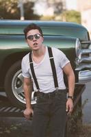 Guy in a shirt with suspenders posing at the retro car photo