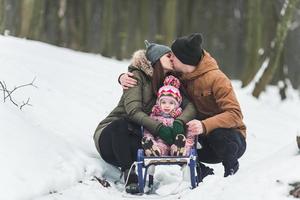 Dad and Mom with a little daughter in the park photo