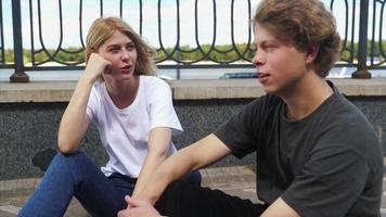 Guy and girl are sitting on the street and talking photo