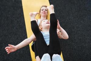 Mom and daughter together perform different exercises photo