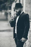 un hombre rico con barba fuma un cigarrillo electrónico foto