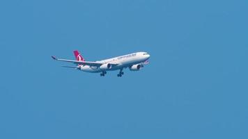 phuket, tailândia, 13 de novembro de 2019 - turkish airlines airbus a330 na aproximação final sobre a praia de mai khao, antes de pousar no aeroporto internacional de phuket em câmera lenta. video