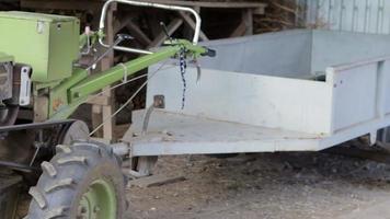 Typical heavy diesel walking tractor with trailer. Agricultural transport equipment of the countryside. Portable agricultural equipment, walking minitractor. Ukraine, Kyiv - June 21, 2022. video