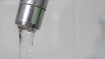 close-up de beber água da torneira fluindo de uma torneira. projetar uma torneira na cozinha ou banheiro. o conceito de economia de água e consumo de água, tarifa e preço da água. video