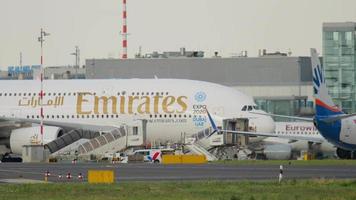dusseldorf, Duitsland juli 23, 2017 - luchtbus a380 van emiraten luchtvaartmaatschappijen aangekomen Bij dusseldorf luchthaven, taxiën naar de terminal, kant visie. breed lichaam dubbele dek vier motor turbojet passagier vliegtuig video