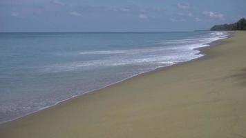vagues turquoises roulées sur le sable de la plage, plage de mai khao, phuket, ralenti video