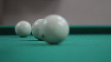 Game of billiards. White billiard balls roll on the table. Sports entertainment in the bar. Simple background with a pool table. Balls hitting and moving. video