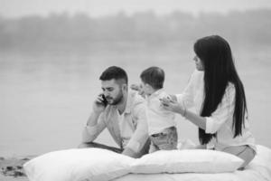 familia joven feliz relajándose juntos en el lago foto