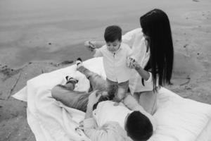 Happy young family relaxing together on the lake photo