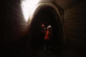 mujer excavadora con linterna explora el túnel foto