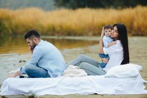 Happy young family relaxing together on the lake photo