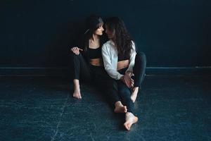 beautiful girls sit by the wall and pose photo