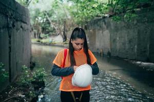 Young beautiful woman digger walks along the rain collector photo