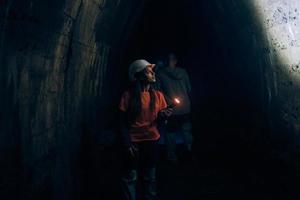 Female digger with flashlight explores the tunnel photo