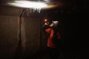 mujer excavadora con linterna explora el túnel foto