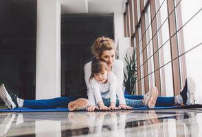 madre e hija se abrazan y se estiran en el gimnasio foto