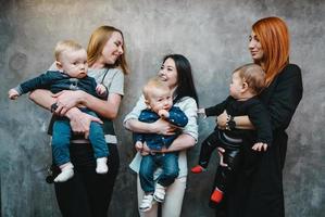 Three moms with their children posing on camera photo