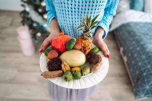 Fruit on a plate in the hands photo