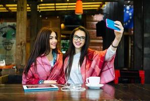 two close friends make selfie in the cafe photo