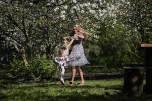 mother twist daughter in the garden photo