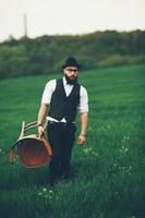 Bearded man carries a chair on the field photo