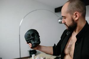 hombre barbudo sosteniendo el cráneo foto