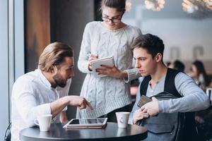 Three Businesspeople Working In cafe photo